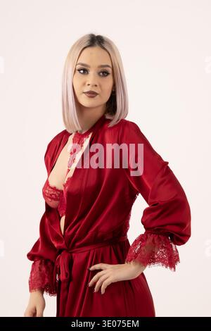 Ritratto di una donna in abito da sera rosso su sfondo bianco Foto Stock