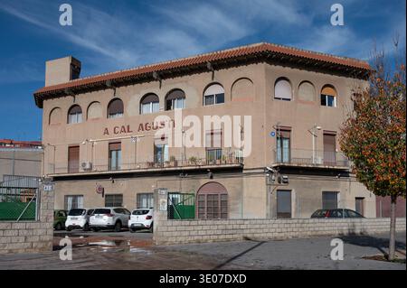 Facciata di Cal Agusti, una tradizionale fattoria storica catalana masia integrata nel paesaggio urbano di Barcellona sotto un cielo azzurro. Foto Stock