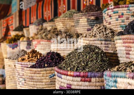 Foglie essiccate di tè alle erbe ibisco e spezie in tradizionali cesti tessuti presso il colorato bazar egiziano Foto Stock