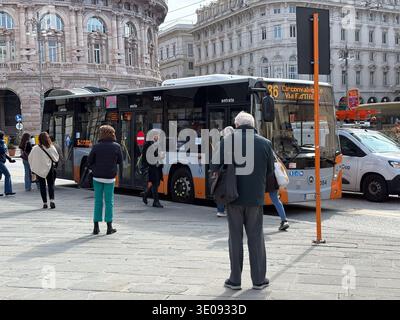 Piazza De Ferrari, Piazza Raffaele De Ferrari. Genova, Italia. Le persone salgono a bordo dell'autobus cittadino di fronte all'ornato palazzo della Borsa del XIX secolo. Foto Stock
