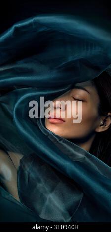 Ritratto di bellezza di donna asiatica avvolta in tessuto di seta verde scuro Foto Stock
