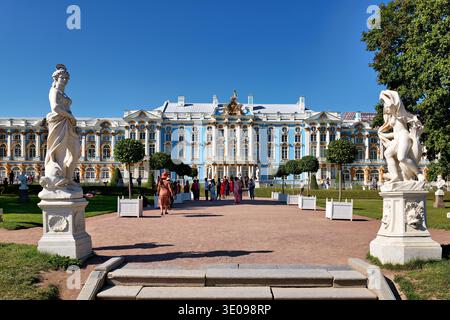 I visitatori camminano di fronte al Palazzo di Caterina a Pushkin, San Pietroburgo. Le statue sono su ogni lato e gli alberi migliorano la vista dell'edificio. Foto Stock