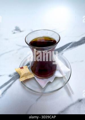 Tradizionale tè nero turco in un tipico bicchiere di tulipano, servito con cubetti di zucchero. Istanbul. Turchia. Foto Stock