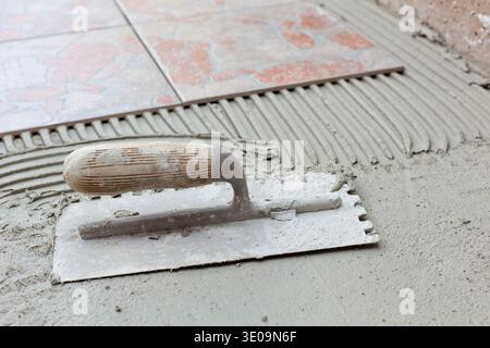 Spatola dentellata per applicazione di adesivi per piastrelle. Foto Stock