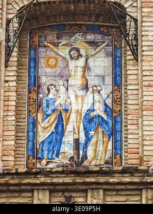 Pannello di piastrelle di ceramica del XVIII secolo sulla facciata del Convento di Espiritu Santo, Siviglia. Raffigura il Calvario con la Vergine Maria e San Giovanni ai piedi della croce. Foto Stock
