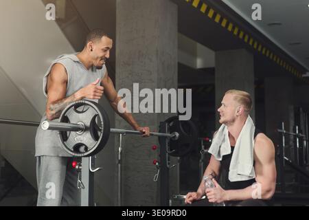 Uomo e personal trainer che si allenano con il manubrio Foto Stock