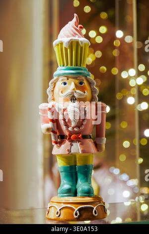 Coloratissima statuetta dello schiaccianoci con luci bokeh festose Foto Stock