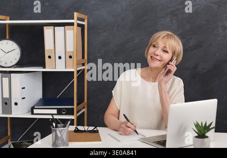 Imprenditore maturo di successo che parla al telefono Foto Stock