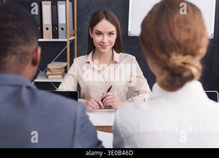 Una giovane donna che ha intervistato due uomini d'affari Foto Stock