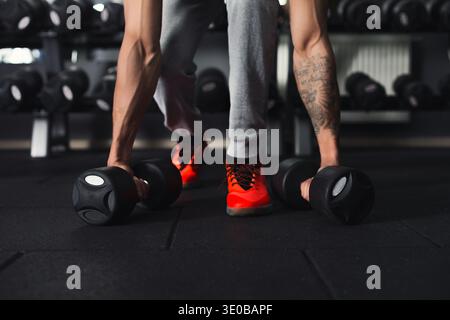 Allestitore non riconoscibile che esegue sollevamenti a vuoto pesanti Foto Stock