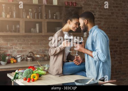 Coppia romantica che brinda a vicenda con bicchieri di vino rosso Foto Stock