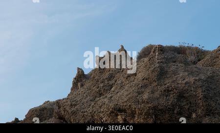 Scogliera rocciosa erosa con picchi frastagliati contro il cielo azzurro Foto Stock