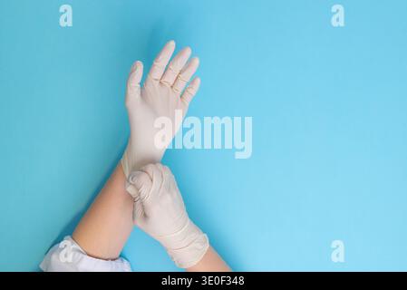 Medico che indossa guanti protettivi in lattice preparazione delle mani per procedure mediche, concetto di igiene, prevenzione delle infezioni e sicurezza sanitaria Foto Stock