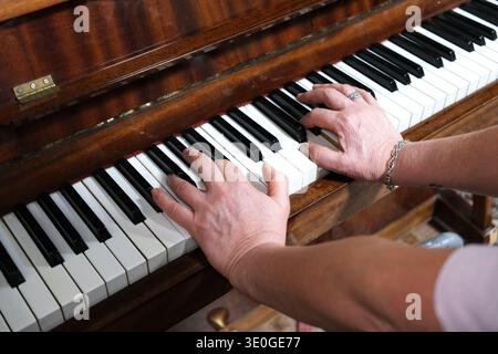 Primo piano di mani che suonano il piano. Mettere a fuoco le dita premendo i tasti Foto Stock