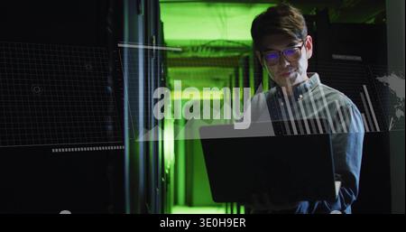 Monitoraggio dell'uomo coreano in camicia a righe, controllo di laptop e scaffali nel corridoio del data center, copia dello spazio. Neon, verde, serverroom, hud, analisi, diagnostica Foto Stock