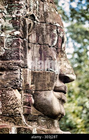 Una vista ravvicinata di un volto in pietra intemprata intagliato nel tempio di Bayon. Questa antica arte raffigura Avalokiteshvara o re Jayavarman VII Foto Stock