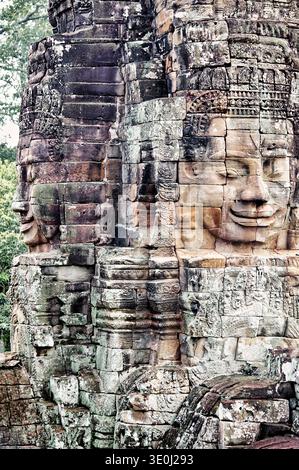 Le pareti in pietra scolpite di Avalokiteshvara si trovano sulle pareti del Tempio Bayon ad Angkor Thom, Cambogia. Queste facce sono una parte fondamentale del tempio. Foto Stock