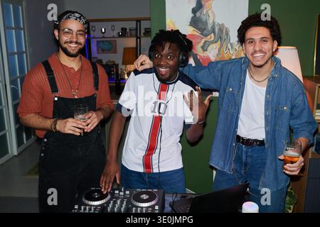 Giovani uomini multietnici sorridenti e godendosi Party con DJ Equipment Foto Stock