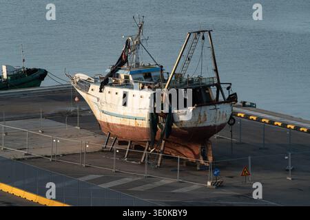Vecchio peschereccio sul molo del porto Foto Stock