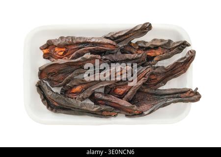 Vista dall'alto. Pere essiccate in un contenitore bianco isolato su fondo bianco. Ingrediente per preparare una colazione liofilizzata e altri piatti. Foto Stock