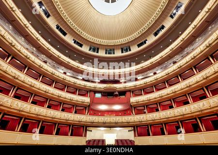 L'interno dell'Opera di Vienna mostra posti a sedere e cabine vuote, evidenziando il grande design dello spazio prima dell'inizio di uno spettacolo. Foto Stock