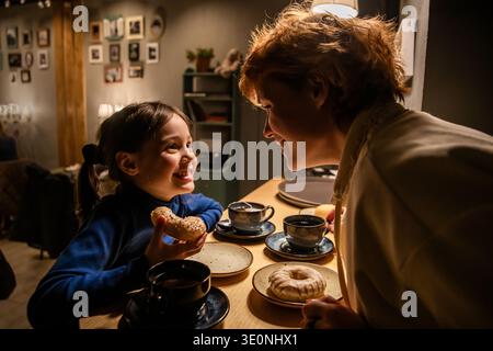 Genitori e bambini sorridenti che trascorrono del tempo insieme in un accogliente ristorante. Foto Stock