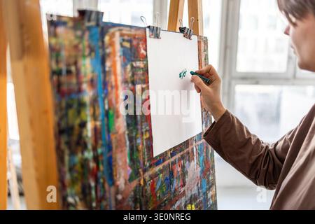 Artista che disegna con pastelli nel suo studio d'arte Foto Stock