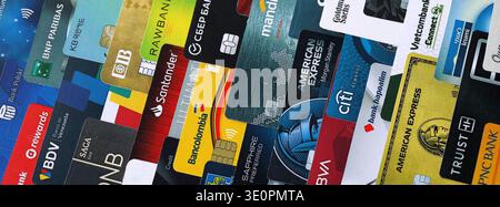 KIEV, UCRAINA - 28 GENNAIO 2026 grande pila di carte di credito con loghi di varie banche di tutto il mondo. Concetto di utilizzo delle carte di credito o di debito. Servizi bancari, Foto Stock