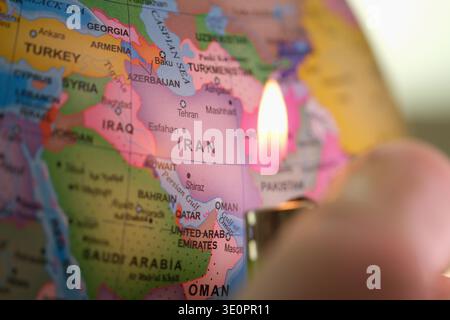 Vista ravvicinata di una mappa dell'Iran con una fiamma che illumina i vivaci dettagli della regione, catturando un momento di creatività e curiosità Foto Stock