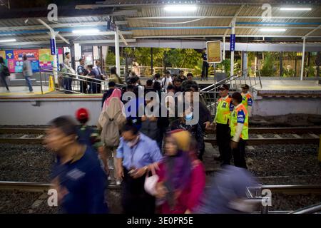 Giacarta, Indonesia – novembre 2025: I pendolari si affrettano su una piattaforma affollata mentre la sicurezza gestisce le folle; la sfocatura del movimento riflette il flusso dell'ora di punta serale. Foto Stock