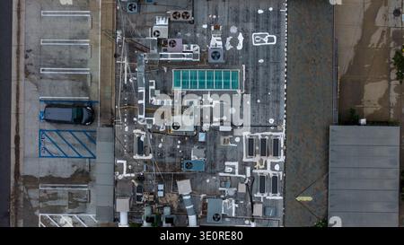 Vista aerea di un tetto con varie strutture meccaniche che gettano ombre, creando un netto contrasto con la superficie intemprata, West Hollywood, Foto Stock