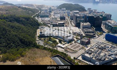 Vista aerea di edifici moderni che si accostano alle lussureggianti colline verdi e al mare tranquillo, Tseung Kwan o, New Territories, Hong Kong. Foto Stock