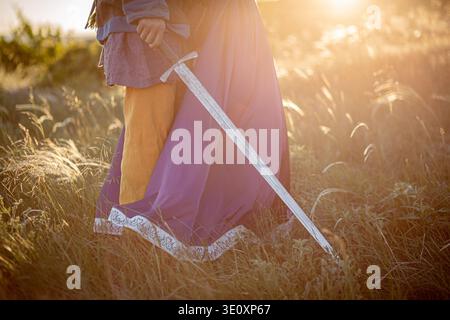 Una donna e un uomo con una spada in costume medievale. Foto Stock