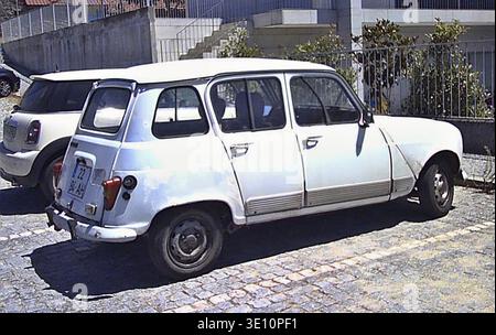 Renault 4L bianca classica parcheggiata in una strada acciottolata in Portogallo, che mostra il suo fascino vintage Foto Stock