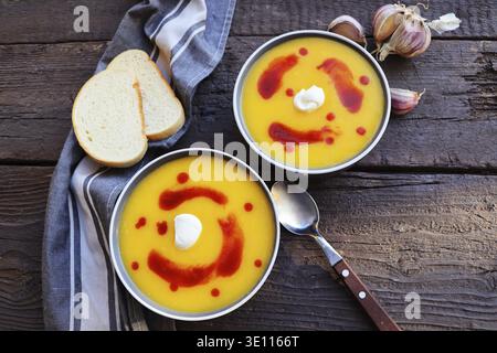 Zuppa di zucca fresca con bruschetta per cena autunnale su tavola rustica Foto Stock