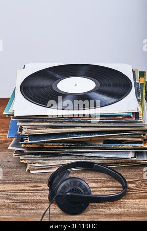 Una pila di dischi in vinile nero e cuffie sulla parte superiore. Persone since, momenti reali, situazioni autentiche Foto Stock