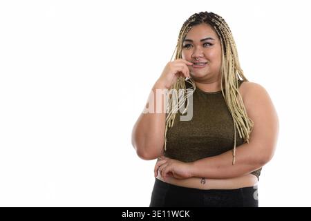 Giovani felici fat donna asiatica sorridere mentre il pensiero e mordere le unghie Foto Stock