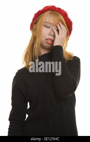 Giovani carino donna asiatica avente mal di testa isolata contro uno sfondo bianco Foto Stock