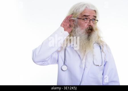 Studio shot di senior uomo barbuto pensiero medico mentre ascolti Foto Stock
