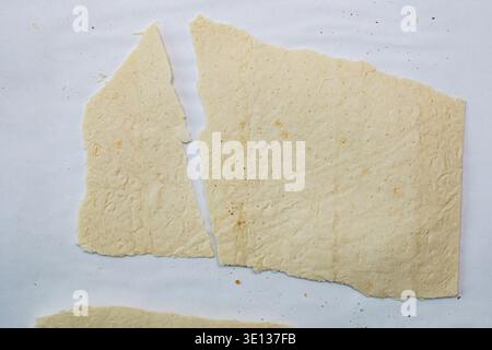 Pezzi di matzo fresco su sfondo bianco. Farine, lavash, impasto arrotolato. Foto Stock