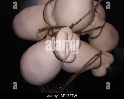 Delizioso formaggio Scamorza fresco appeso Foto Stock