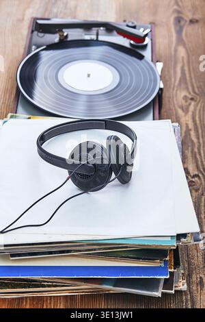 Una pila di dischi in vinile nero, un lettore giradischi in vinile e cuffie. Set stereo classico. Gente sincera, momenti reali, autentica Foto Stock