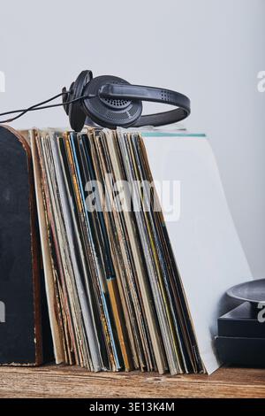 Una pila di dischi in vinile nero, un lettore giradischi in vinile e cuffie. Set stereo classico. Gente sincera, momenti reali, autentica Foto Stock