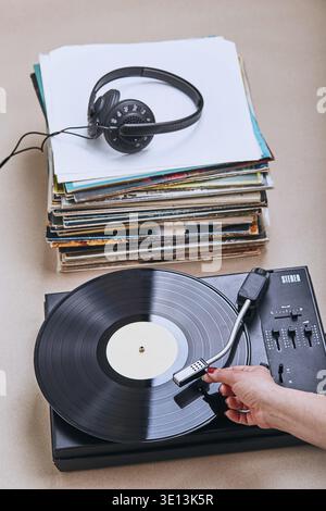 Una pila di dischi in vinile nero, un lettore giradischi in vinile e cuffie. Set stereo classico. Gente sincera, momenti reali, autentica Foto Stock