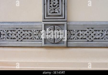 Una croce con un simbolo celtico al centro. Il simbolo è un cerchio con quattro linee. La croce è in metallo Foto Stock