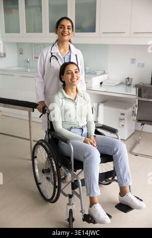 Ritratto di un medico in piedi dietro una paziente in sedia a rotelle Foto Stock