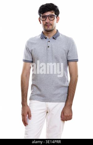 Studio shot di Persiano giovane uomo in piedi indossando occhiali da vista Foto Stock