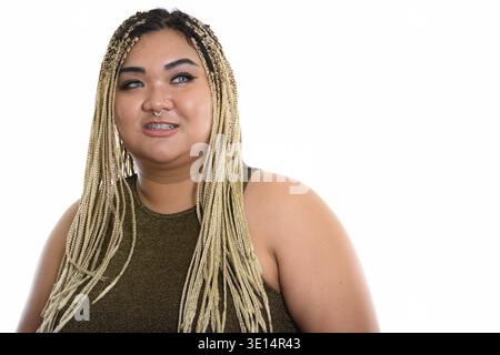 Studio shot di giovani felici fat donna asiatica sorridere mentre pensando Foto Stock