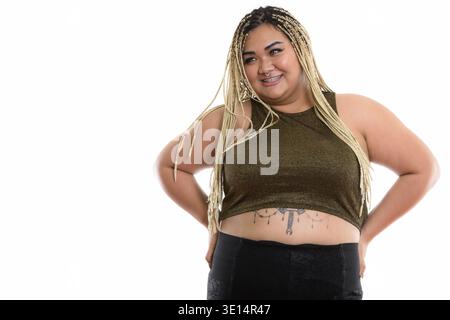 Studio shot di giovani felici fat donna asiatica sorridere mentre pensando Foto Stock