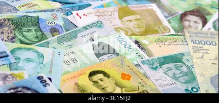 Varie valute banconote banconote di colore verde. Molte banconote in contanti da diversi paesi in grande pila da vicino. Economia mondiale e concetto di cambio valuta Foto Stock